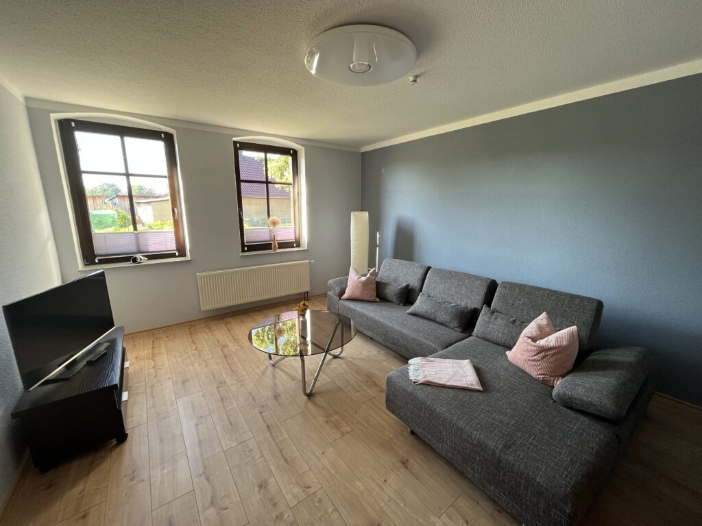 Helles Wohnzimmer der Fewo Cottbus mit Couch und Couchtisch